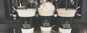 new restaurants: 3 cups of cold coffees, one with whip cream that say human bean on the sleeves