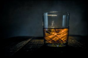 Bourbon: a glass of bourbon with a dark background