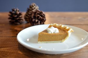 Thanksgiving: piece of pumpkin pie on a white plate